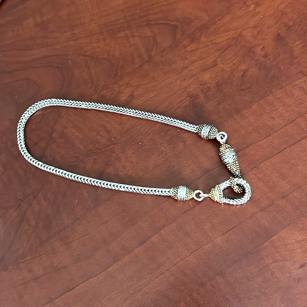 Silver tone thick necklace with two tone hook clasp.